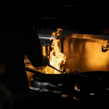 Cuisson flamboyante d'un plat dans une cuisine professionnelle