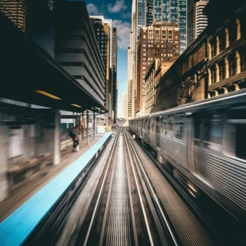 Vue dynamique d'un train urbain circulant à grande vitesse au milieu des gratte-ciel d'une ville